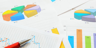 Bunte Kreis- und Balkendiagramme und ein Graph im Detail auf verschiedenen Seiten, die übereinander liegen. 