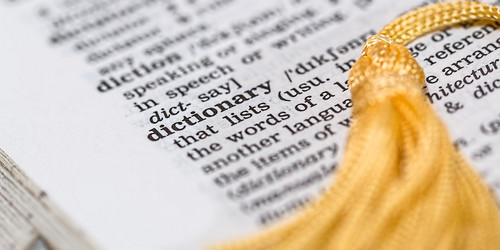 An open page of an english dictionary with a yellow bookmark.