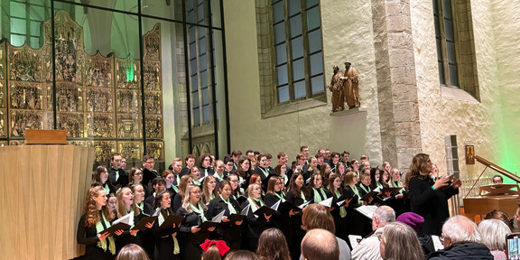 Der Unichor vor dem Altar in der Petri-Kirche. Rechts im Bild steht die Chorleiterin Heinke Kirzinger.